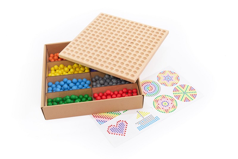 Kugelbrettspiel - in geöffneter Karton mit einem Steckspielbrett und farblich sortierten Steckkugeln in Orange, Blau, Grau, Grün und Rot, daneben liegen Vorlagenkarten mit verschiedenen Mustern.